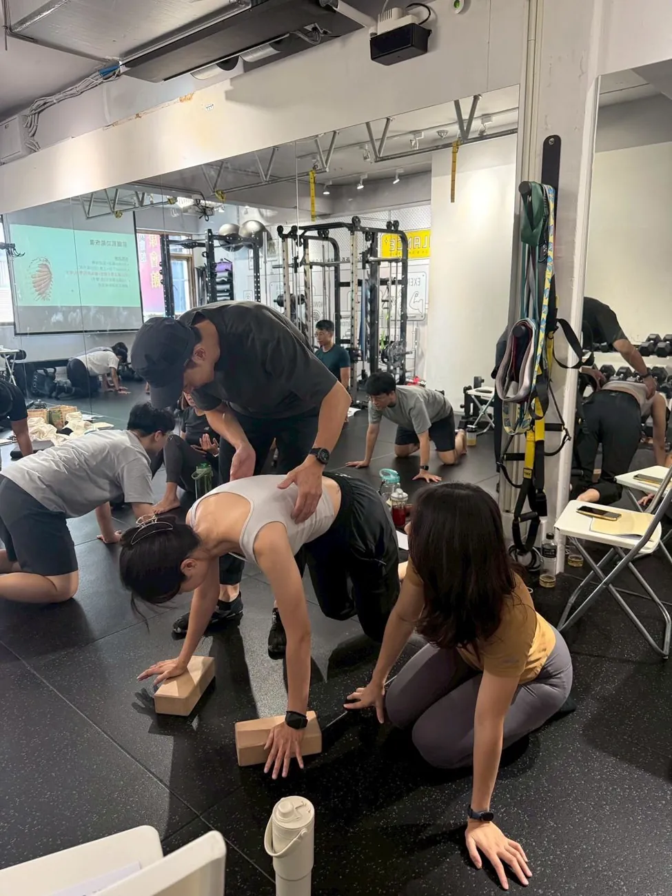 學員圍在現場，觀察教練示範墊上動作