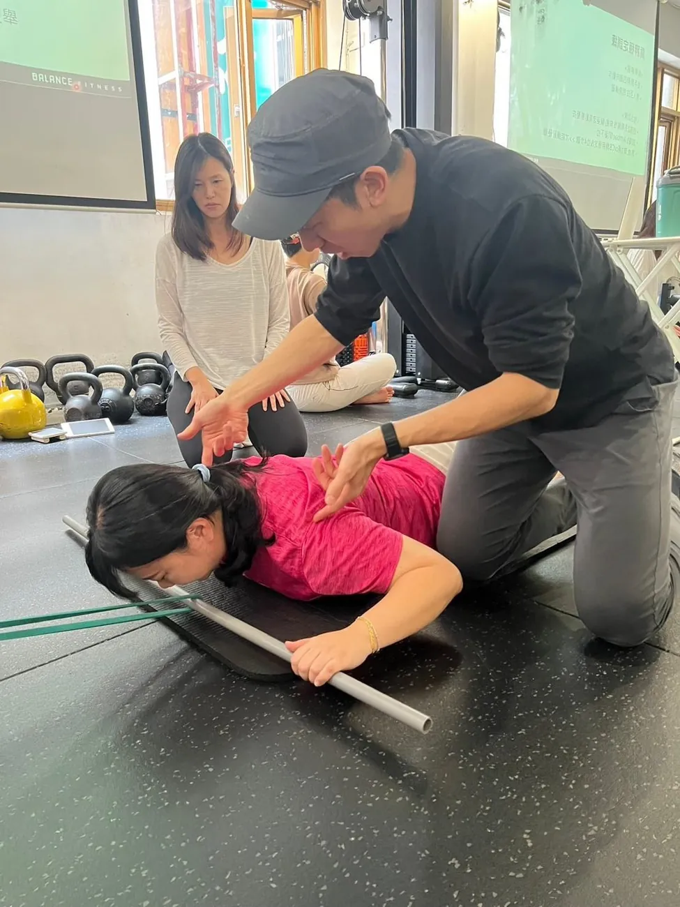 教練在墊上協助學員調整動作